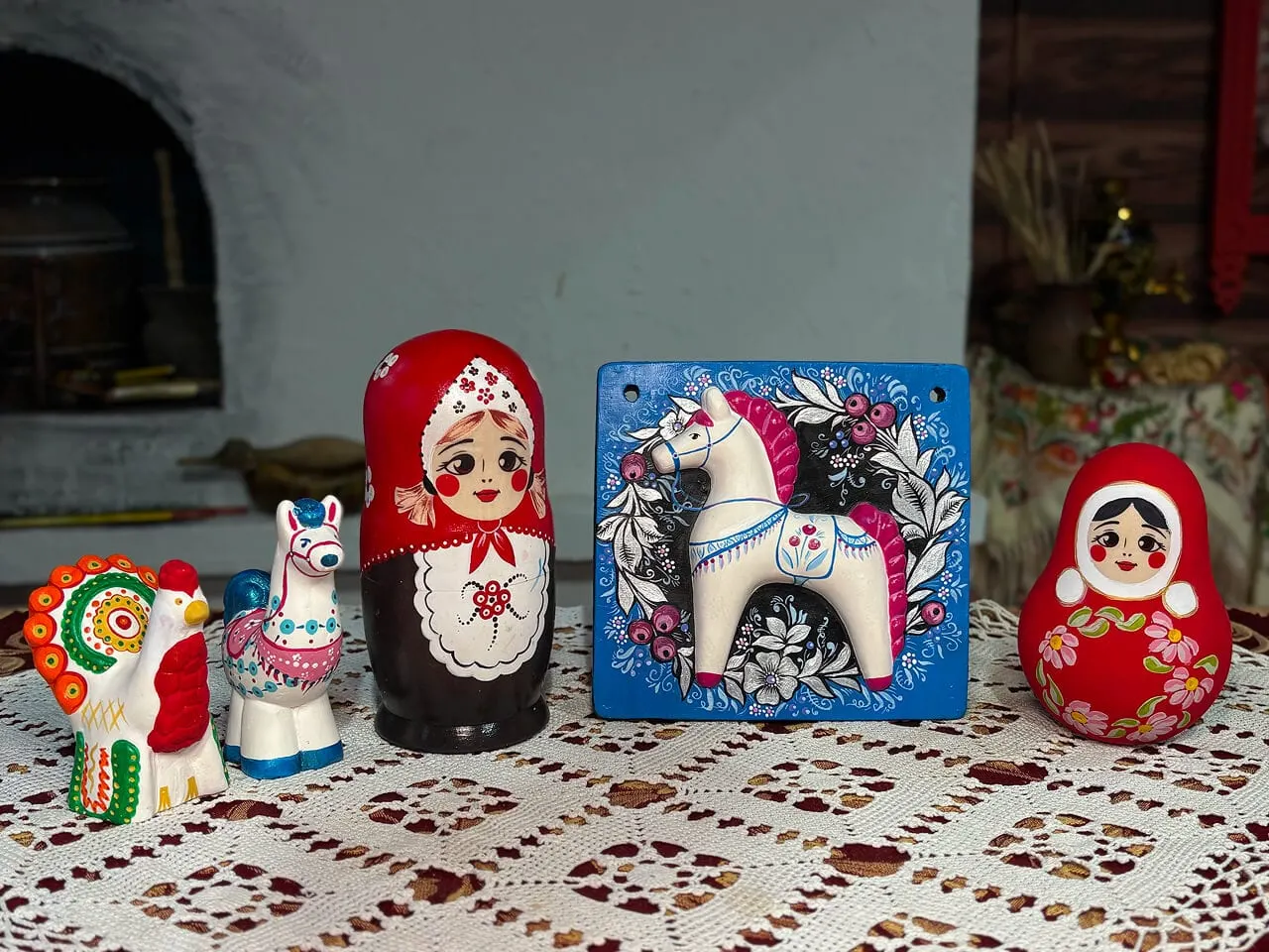 Расписанные петушок, лошадка, матрёшка, панно и неваляшка на кружевной скатерти